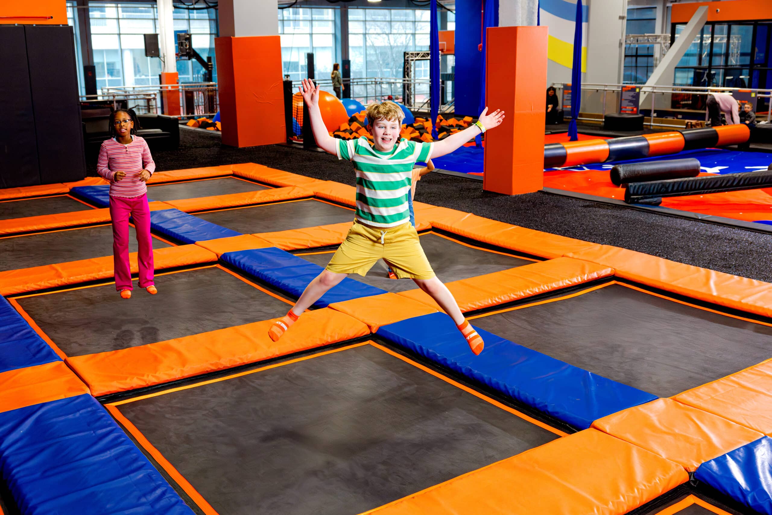 A kid jumping on a trampoline at an indoor playground, Sky Zone